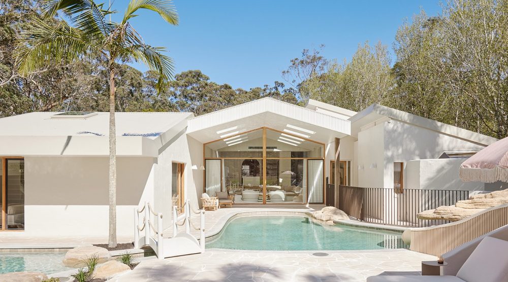 View of The Ambers property showing a large lagoon style pool and floor to ceiling windows